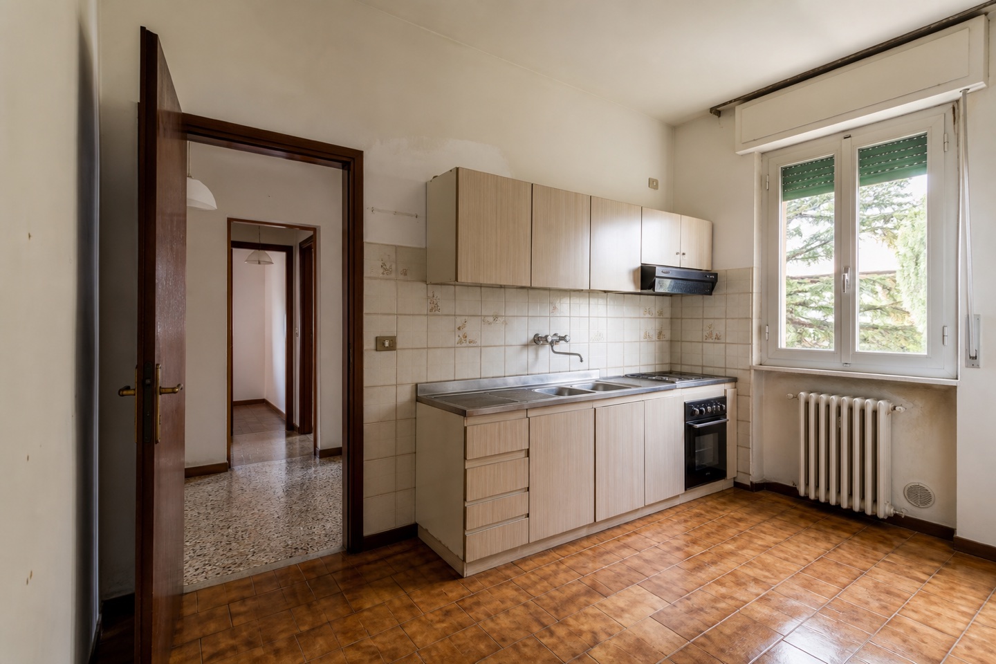 Cucina prima della ristrutturazione, con finiture e arredi datati